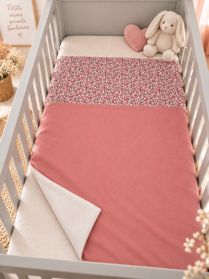 Couverture bébé avec tissu Liberty fleuri présentée dans une chambre d’enfant
