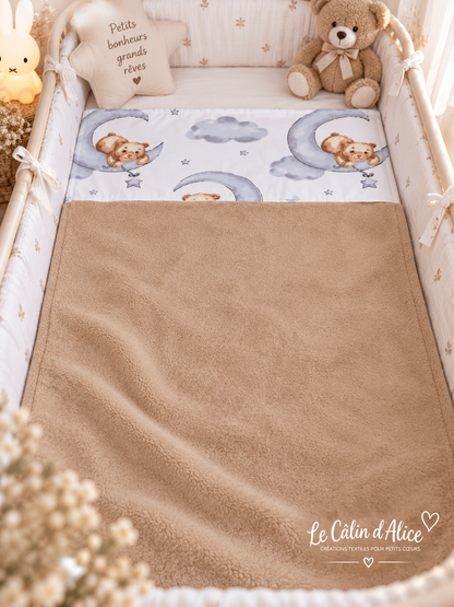 Couverture bébé motif ours qui dort présentée dans une chambre d’enfant