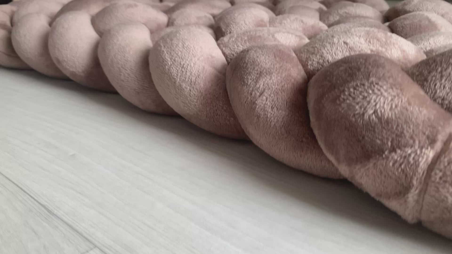 Tapis tressé rembourré moka en tissu minky doudou au pied d’un lit enfant